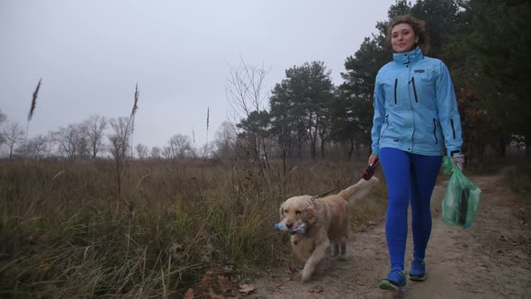 Labrador Retriever Helping Woman Picking Up Litter