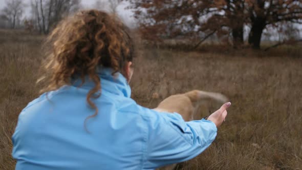 Female Owner Calling Her Dog in Autumn Nature