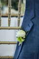 boutonnière on grooms jacket hanging over a chair at wedding - PhotoDune Item for Sale