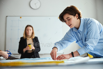 Focused female tailor circling the pattern with chalk / Photodune, Misc