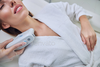 Adorable woman with cute smile and close eyes enjoying treatment procedure in spa salon / Photodune, Misc