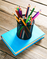 Pencils and book . On wooden background. - PhotoDune Item for Sale
