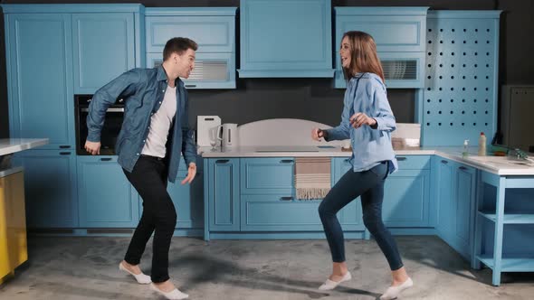 Happy Family Dance. Young Couple Fun Dancing While Cooking in the Kitchen at Home. Rock and Roll