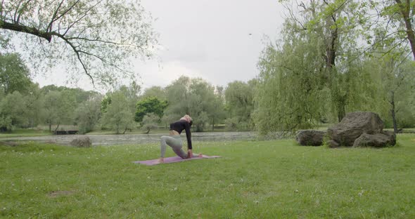 Fit Woman Doing Morning Yoga Exercises in the Park