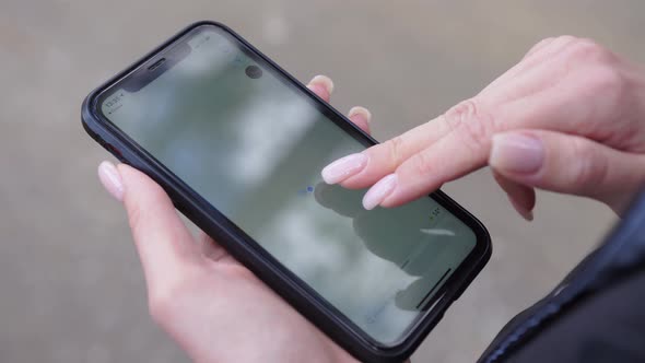 Woman Looks Cards on a Smartphone