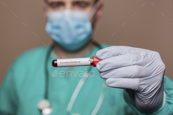 Surgeon holding a covid-19 test tube / Photodune, Misc