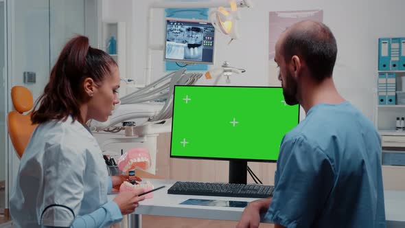 Dentist and Nurse Looking at Green Screen on Monitor