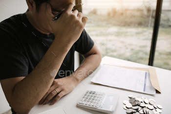 ith invoices and calculators placed on the table while having stress on problems with home expenses.