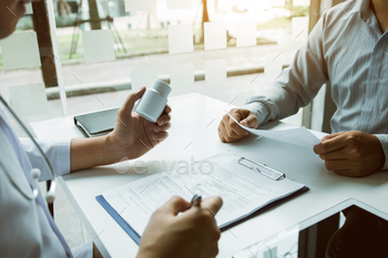 薬瓶を持って先輩患者と話している自信のある医者の男 / Photodune, Misc