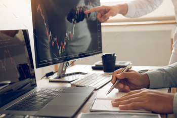 investors are working together with analyzing the stock data graphs in the paper / Photodune, Misc