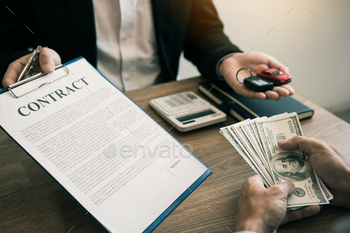 New car buyers are holding cash and handing it to car salespeople while filing a new car / Photodune, Misc
