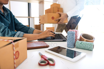 business owner are working together to pack products and check customers / Photodune, Misc
