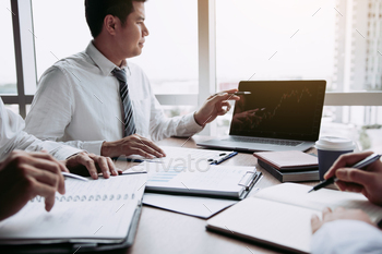 he company financial statements in the computer screen and together analysis the work room.