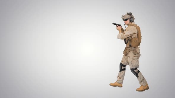 Soldier Walking Aiming with a Pistol and Shooting To Camera on Gradient Background