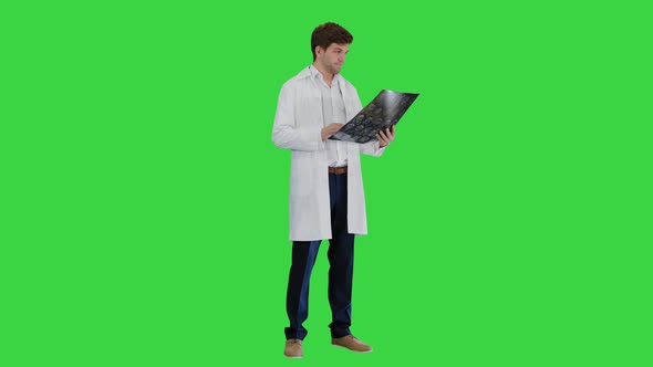 Male Doctor Checking Computed Tomography and Looking at Someone Approvingly on a Green Screen