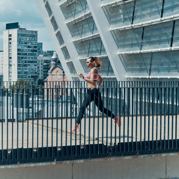 Full length side view of beautiful young woman in sports clothing running outdoors / Photodune, Misc