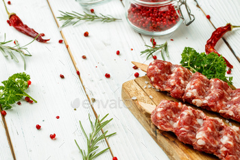 Raw lula kebab on skewers with spices on wooden board / Photodune, Misc