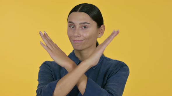 Latin Woman No Sign By Arm Gesture, Yellow Background 