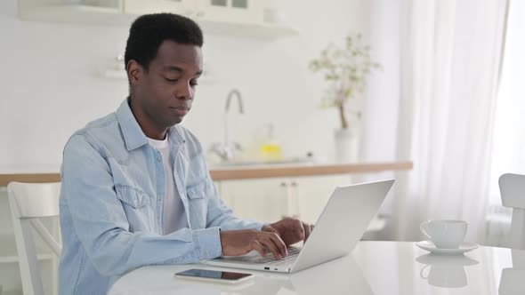 Thumbs Down By African Man with Laptop