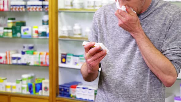 Customer checking medicine box while sneezing