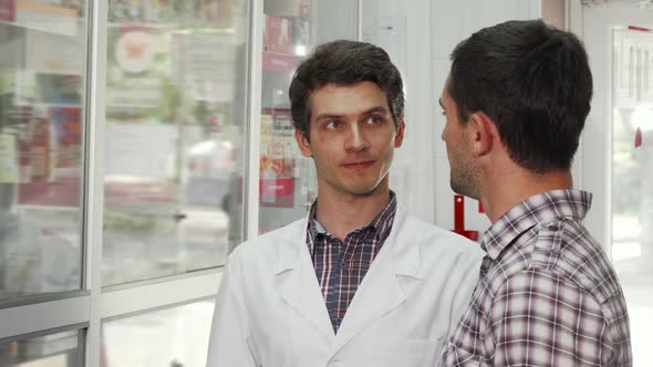 Cheerful Pharmacist Helping Male Customer Choosing Products To Buy