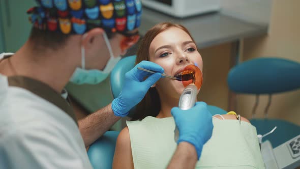 Young Pretty Girl Is in Dental Cabinet on Treatment and Dental Cleansing. 