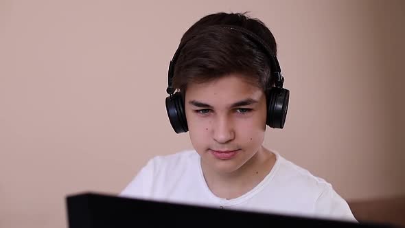 Teenage Boy Playing Game on Laptop in His Room