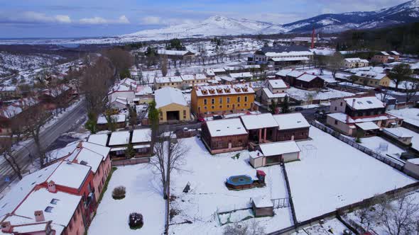 Low cinematic aerial over the snow-covered buildings and streets of Spains Pradera in the midst of w