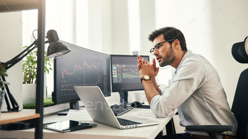 asses looking at analyzing trading charts on computer screens in while sitting in his modern office. Stock broker. Forex market. Trade concept