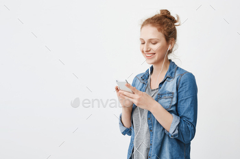 髪をとかしたゴージャスな赤毛の10代の少女の屋内ショット、テキストメッセージを送信しながら広く笑う / Photodune, Misc