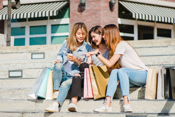 Attractive beautiful asian woman using a smartphone while shopping in the city. / Photodune, Misc