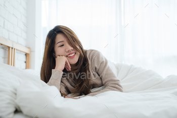 Portrait beautiful young Asian woman on bed at home in the morning. / Photodune, Misc