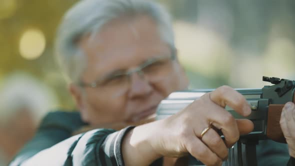 Elderly Gray Haired Man Holding a Gun in His Hands. Hunting Season