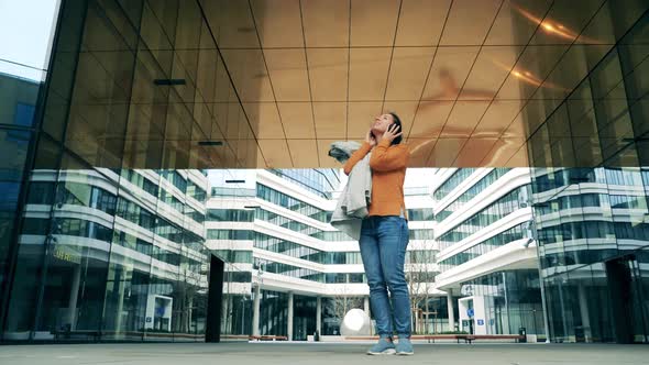 A Woman Is Leaving a Modern Urban Area While Listening To Music