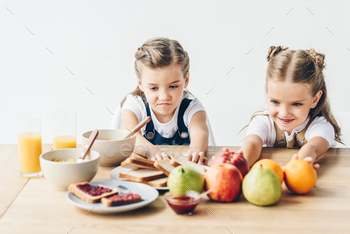 little sisters do not want to eat healthy breakfast isolated on white / Photodune, Misc