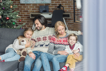 happy family with two children sitting together on couch at christmas time / Photodune, Misc