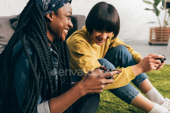 young laughing multiethnic female friends with joysticks / Photodune, Misc