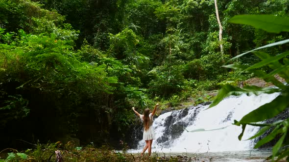 Traveler Woman Walking Front of Cascade Tropical Waterfall Enjoying Nature