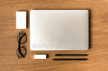 flat lay with arranged laptop, eyeglasses, blank cards, pen and pencil on wooden tabletop / Photodune, Misc