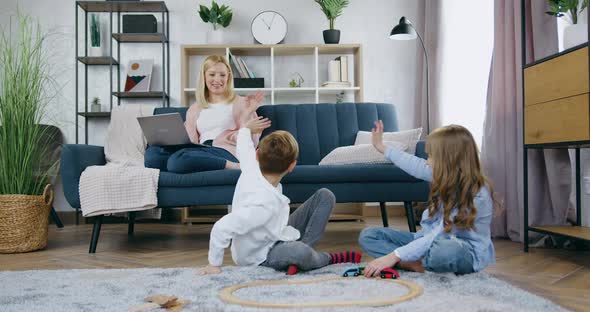 Brother and Sister Having Fun Together while Playing with Car Track and Waving Hands to Say Hello