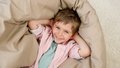 Portrait of happy smiling boy lying in beanbag and looking up in camera - PhotoDune Item for Sale