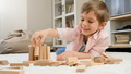 Little boy building house from toy wooden blocks on floor at living room. Concept of child education - PhotoDune Item for Sale