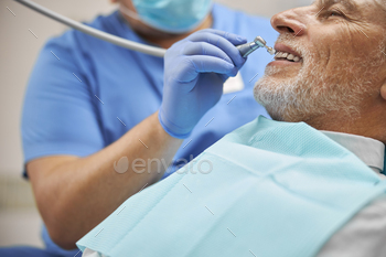 ng a dental burnisher to treat teeth of an elderly patient