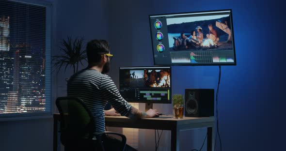 Young Man Sitting Back and Editing Video Inside a Room