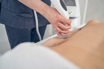 trasonic machine and applying it to the arm of her client