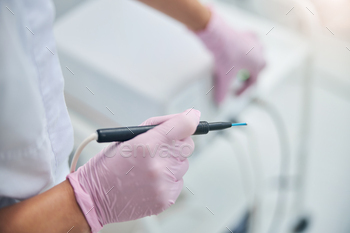 rile latex gloves holding a needle electrode