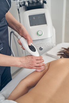 tologist using ultrasonic cavitation on her arm with hand probe