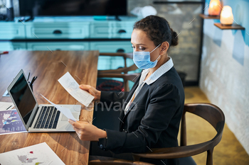 Attentive brunette woman looking at her notices / Photodune, Misc