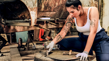Attractive young woman mechanical worker repairing a vintage car in old garage. / Photodune, Misc