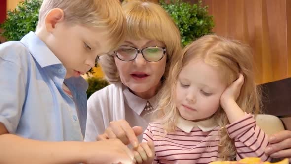 Kids Playing on Tablet with Grandmother